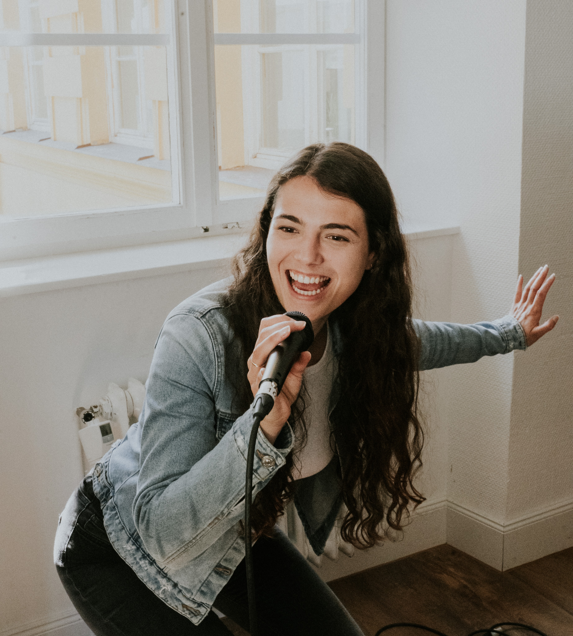 Noemi Fabry beim fröhlichen Singen mit Mikrofon - die pure Freude am Gesang und Vocal Coaching